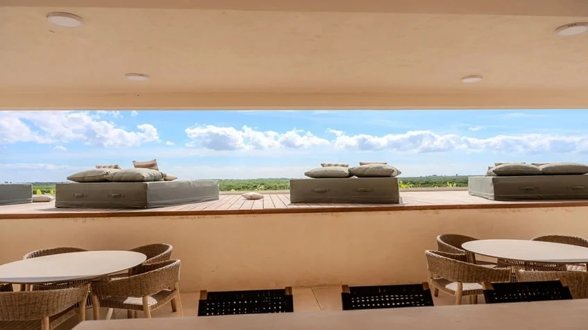 un area de camastros con mesas y sillas en samsara tulum