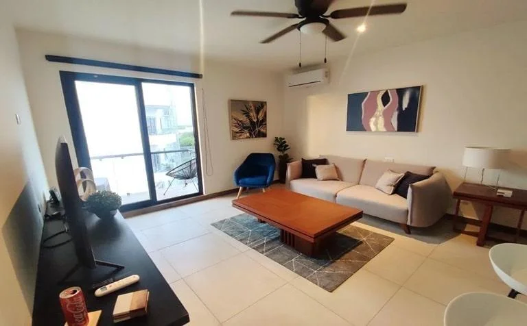 una sala, un sofa, un cuadro decorativo y un balcon en mya black diamond playa del carmen