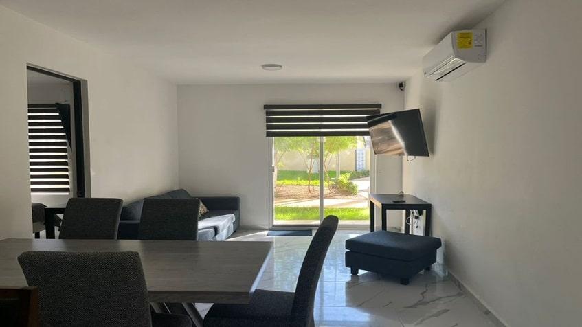 una sala con vista al balcon en la selva residences playa del carmen