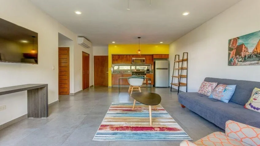 una sala, un comedor, un sofa cama y un cuadro decorativo en puerta zama tulum