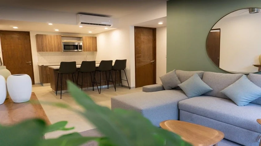 un sofa y una cocina en urban towers playa del carmen