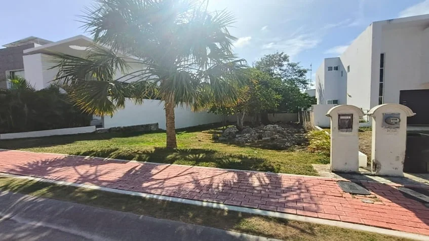 una fachada de varias casas en renta con un lote al lado en playa magna playa del carmen