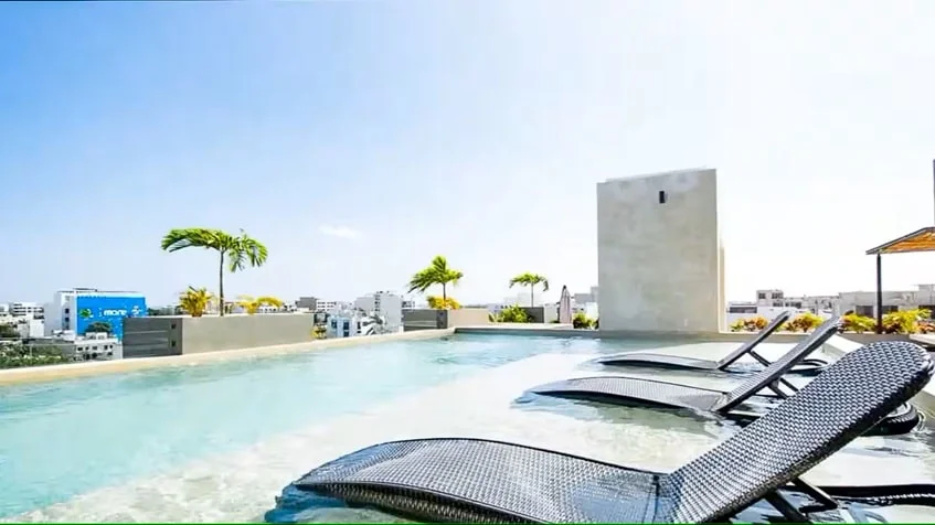 un area de terraza con camastros y alberca en zazil 20 playa del carmen
