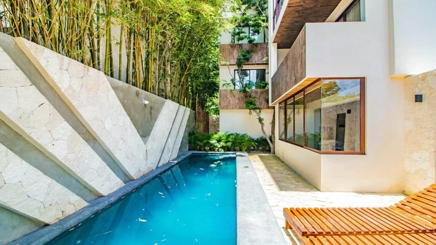una alberca comun con camastros en verandas condos playa del carmen