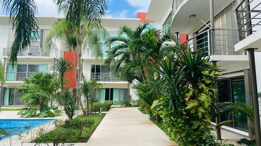 un pasillo con acceso a las areas comunes en edificio palmeiras playa del carmen