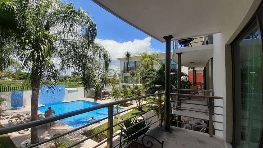 un balcon con vista a la alberca en edificio palmeiras playa del carmen