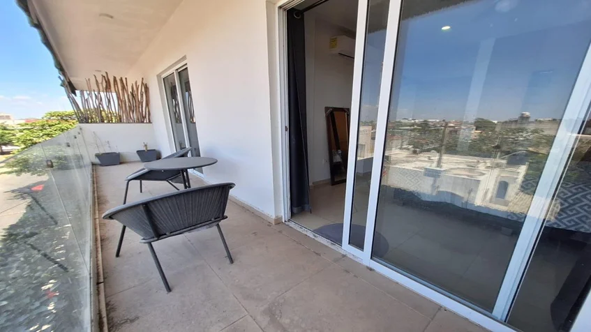 un balcon con vista a la calle y un mesa pequeña en yaakun condos playa del carmen