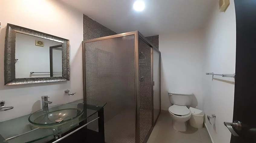 un baño con una ducha, un espejo grande y un lavamanos en edificio palmeiras playa del carmen