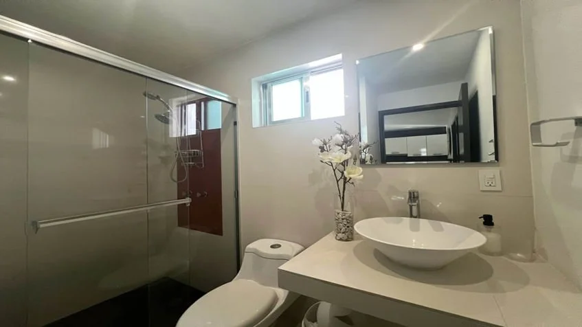 un baño completo con un lavamanos y una ducha en condominio anemonas playacar