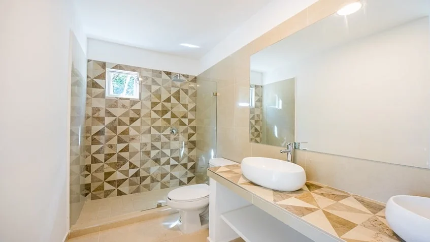 un baño elegante con un espejo grande en ocean blue playa del carmen
