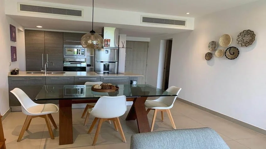 un comedor de cristal y una cocina equipada en lorena ochoa residences playa del carmen