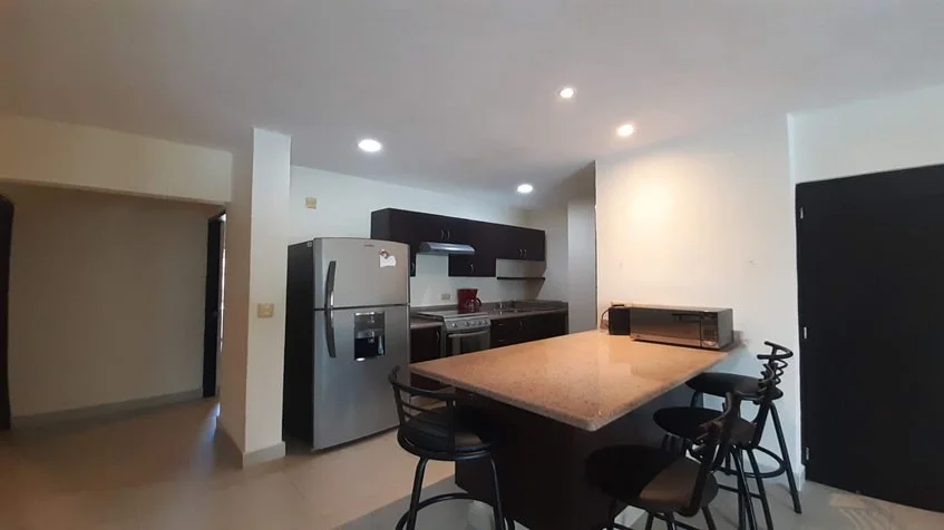 un comedor y una cocina con estufa a gas en edificio palmeiras playa del carmen