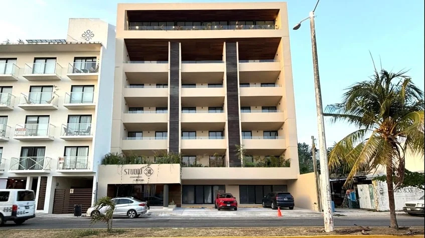 una fachada de un edificio nuevo con departamentos en venta en studio 34 playa del carmen