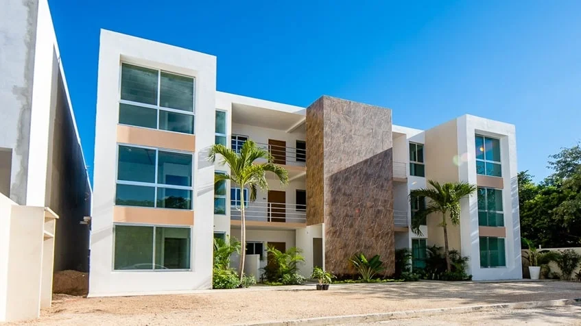 una fachada de un edificio con departamentos en ocean blue playa del carmen
