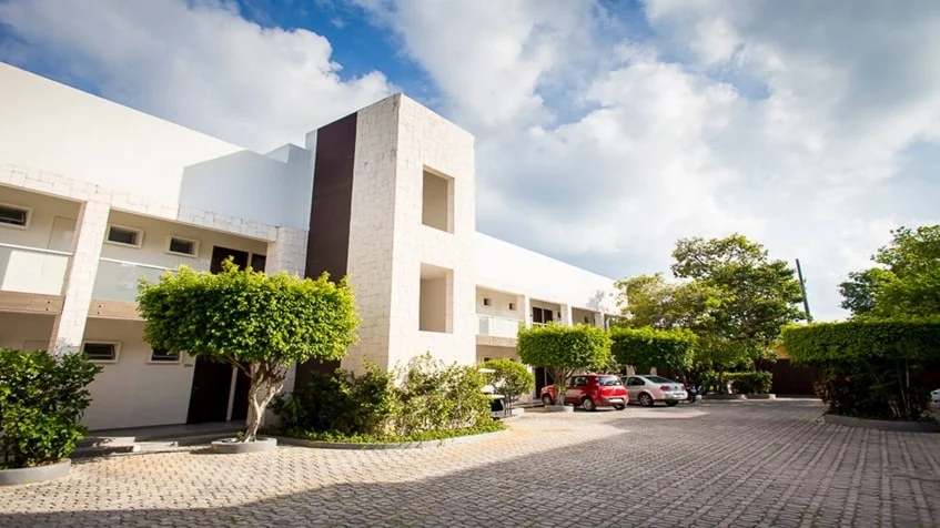 una fachada interior con estacionamiento para varios carros en condominio akab playacar