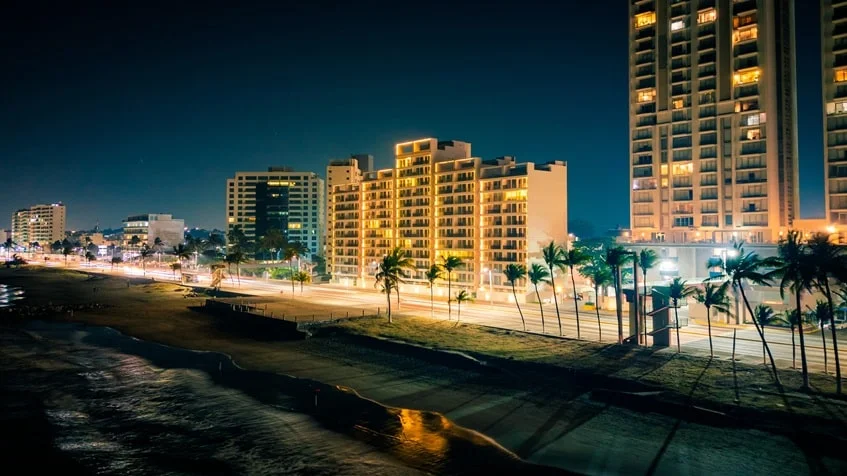 una fachada de varios edificios con vista al mar y una playa en Palms Residences Veracruz