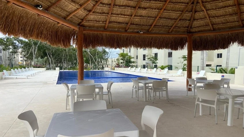 una palapa con mesas y sillas para residentes en aldea tulum