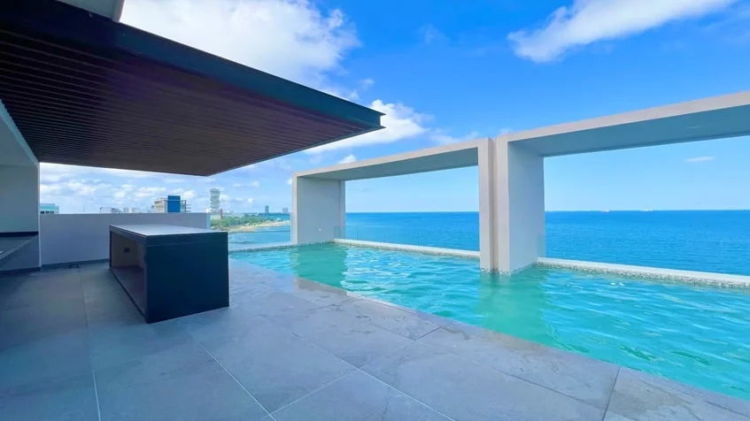 un area de alberca con vista al mar en Palms Residences Veracruz