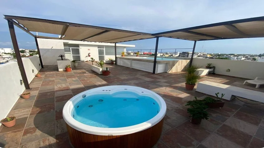 un jacuzzi en la terraza y una alberca en yaakun condos playa del carmen
