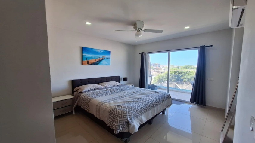 una cama matrimonial con balcon en yaakun condos playa del carmen