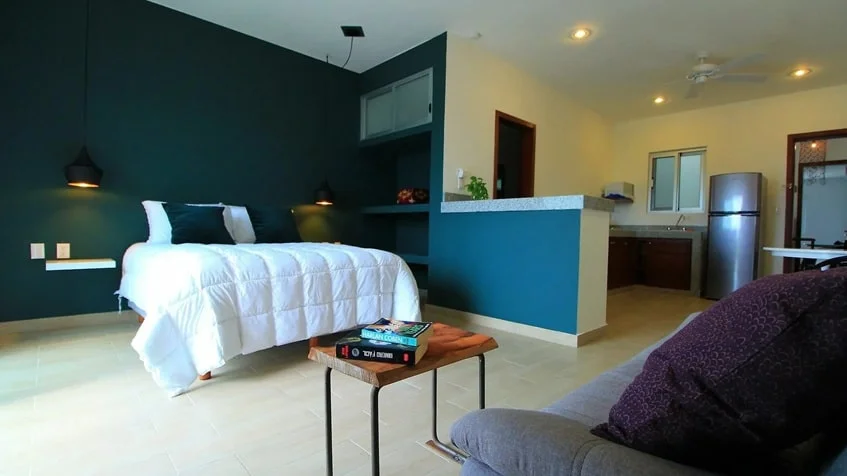 una cocina equipada, una cama, un sofa y un refrigerador grande en casa mora suites playa del carmen