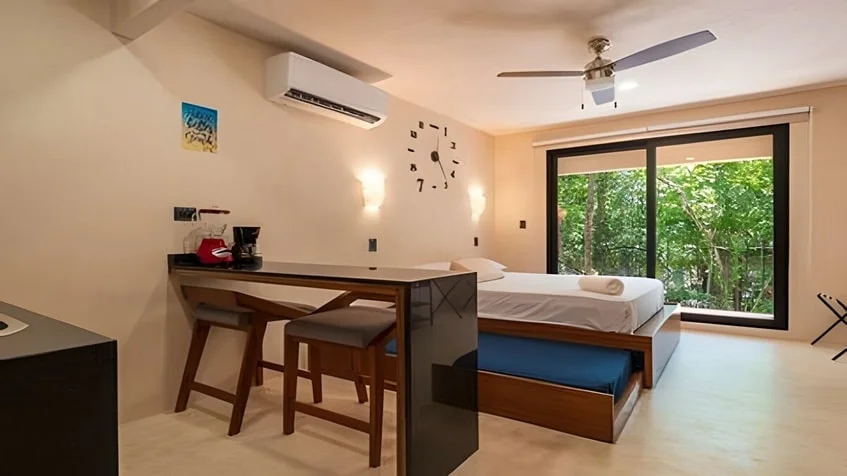 una recamara de un estudio con balcon y vista al exterior en Kantuun Tulum