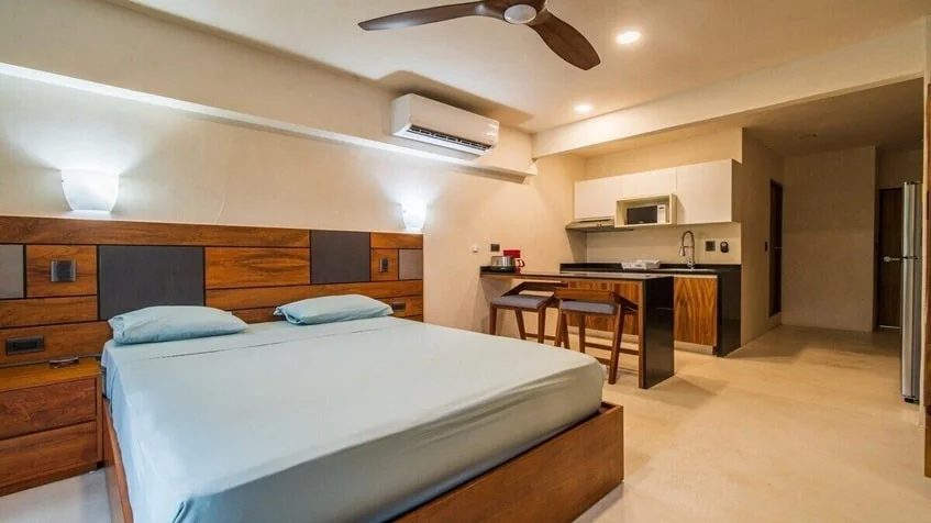 una cama de un estudio, un ventilador de techo y una cocina equipada en Kantuun Tulum