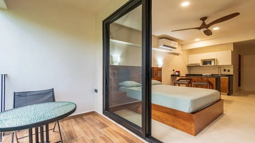 una recamara con una cama matrimonial y una cocina equipada en Kantuun Tulum