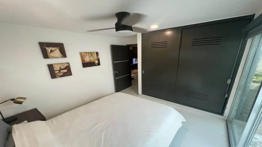 una recamara principal, 3 cuadros decorarivos y un closet grande de madera en condominio anemonas playacar