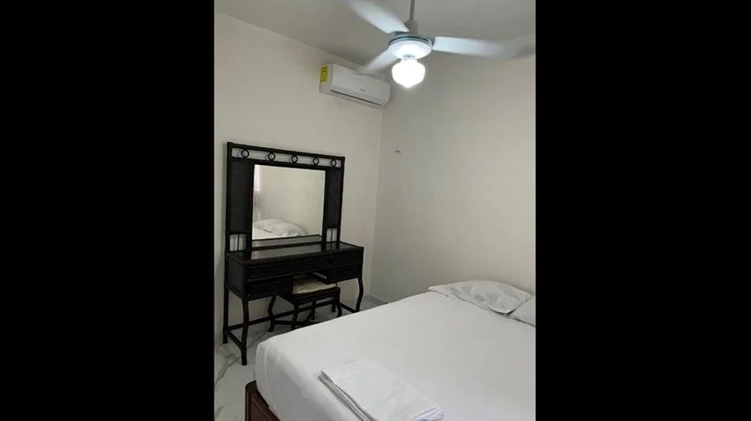 una recamara secundaria con un ventilador de techo y un tocador en aldea tulum