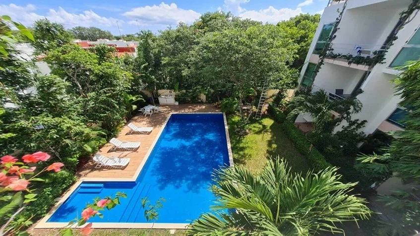una alberca vista desde arriba con areas verdes alrededor en ocean blue playa del carmen