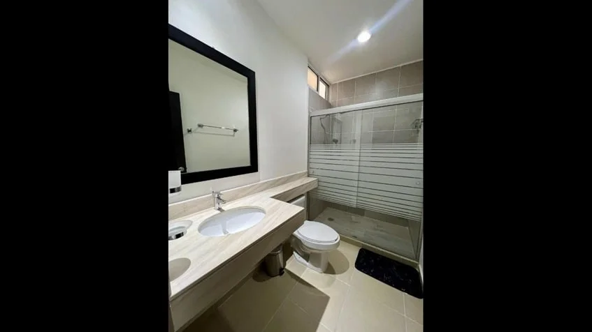 un baño completo con un lavamanos en condominio alegro playa del carmen