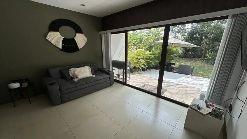 una sala con una terraza con vista al jardin en golf drive playacar