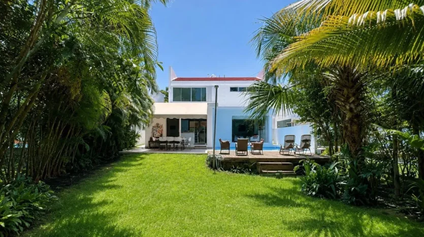 un jardin grande con una piscina privada al fondo en club real playacar playa del carmen