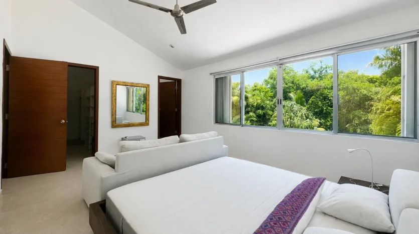 una recamara con un sofa cama y un ventilador de techo en club real playacar playa del carmen