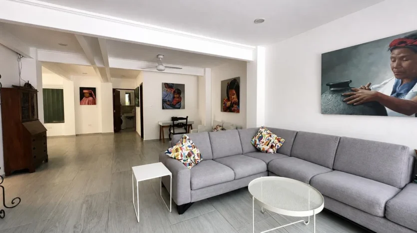 un sofa en forma de L y un cuadro decortativo de una mujer en club real playacar playa del carmen