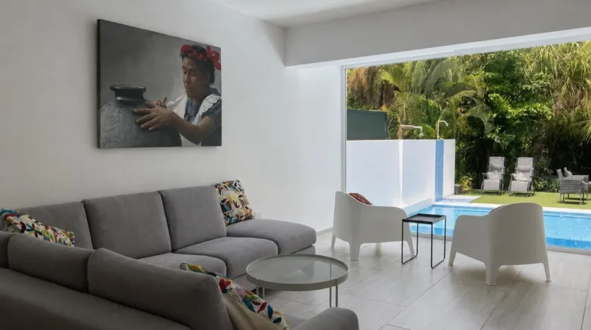 un sofa con vista a la piscina y un cuadro decorativo en club real playacar playa del carmen