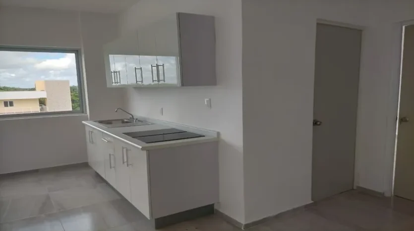 una cocina con una parrilla electrica y gabinetes en condo jim ejidal playa del carmen