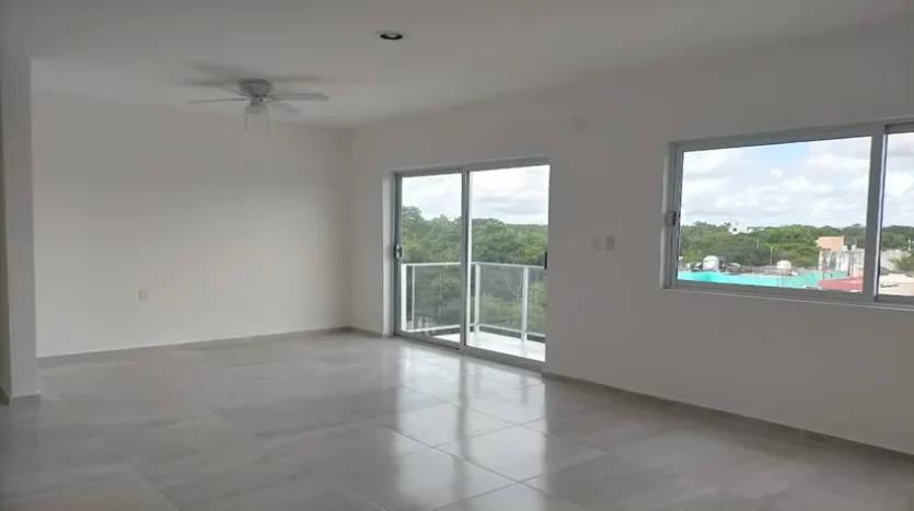 una recamara con un balcon en condo jim ejidal playa del carmen