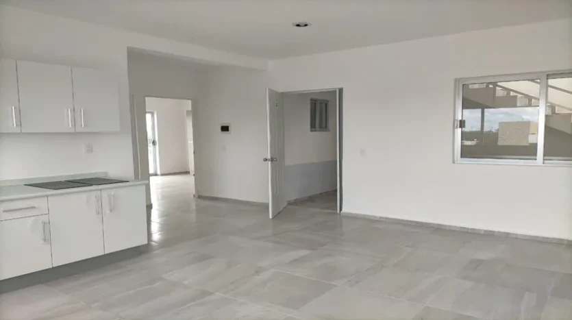 una cocina amplia con una recamara al fondo en condo jim ejidal playa del carmen